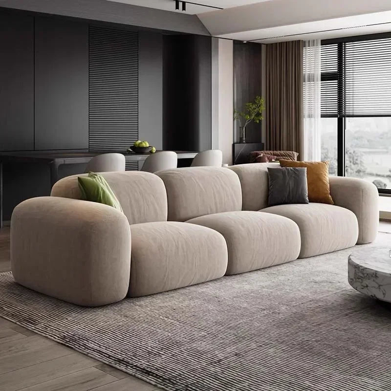 Modern living room with a beige sofa and decorative pillows.