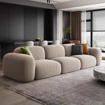 Modern living room with a beige sofa and decorative pillows.