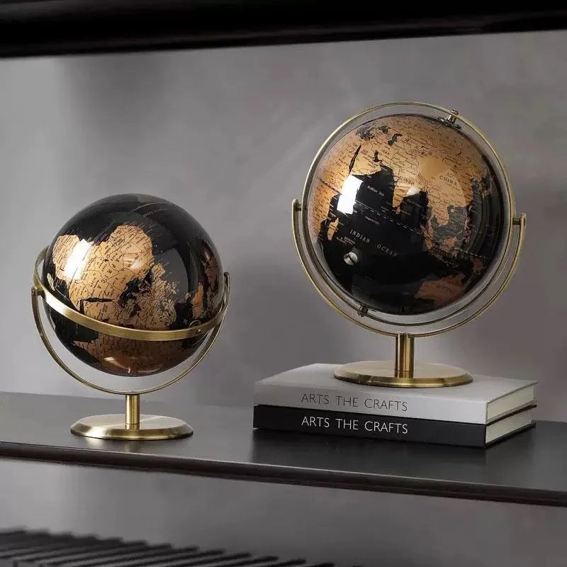 Two decorative globes on a shelf with a neutral background