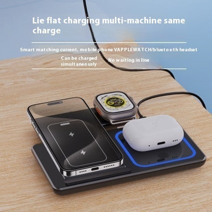 Wireless charging pad with smartphone, smartwatch, and wireless earbuds on a wooden surface.