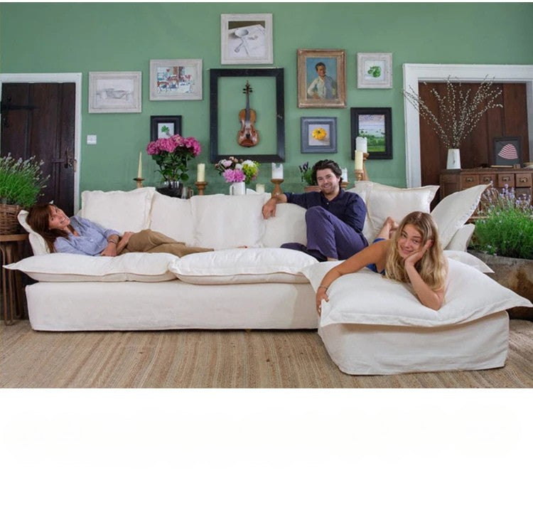 Two people relaxing on a large white sectional sofa in a living room with decorative elements.