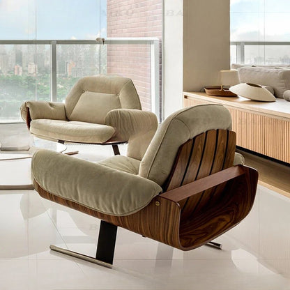 Modern armchair with wooden armrests in a bright room with large windows.