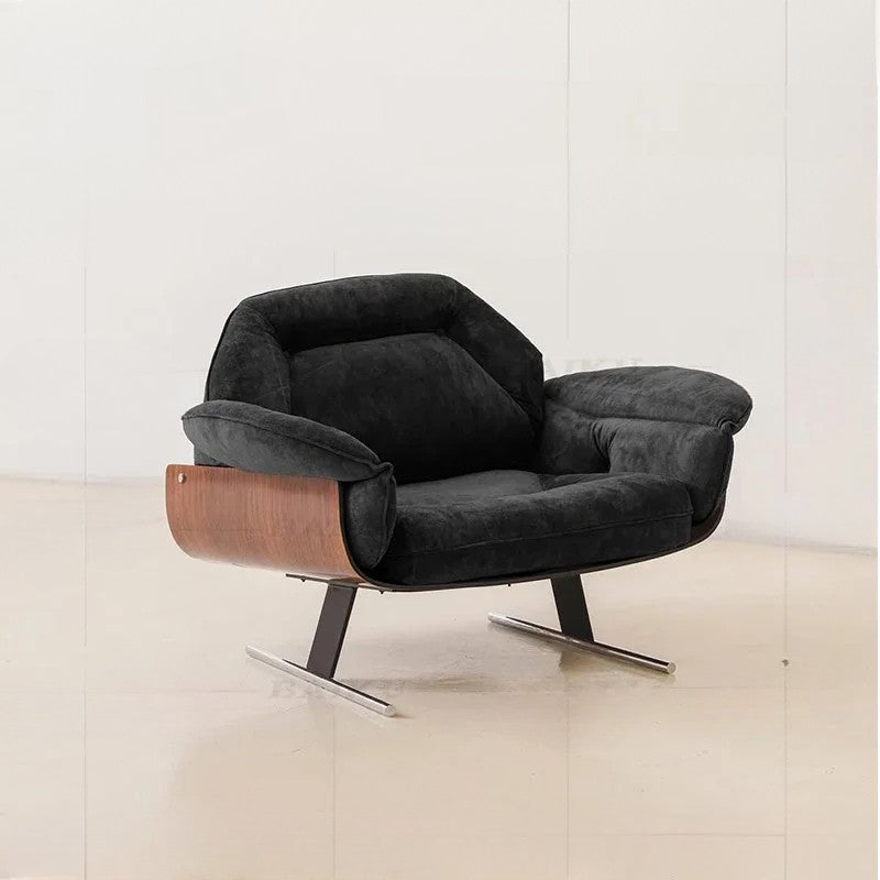 Modern black armchair with wooden accents on a light wooden floor.