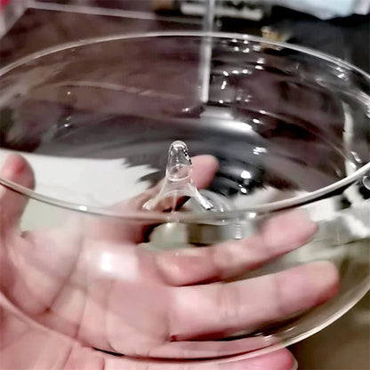 Clear glass lid held by a hand with a blurred background