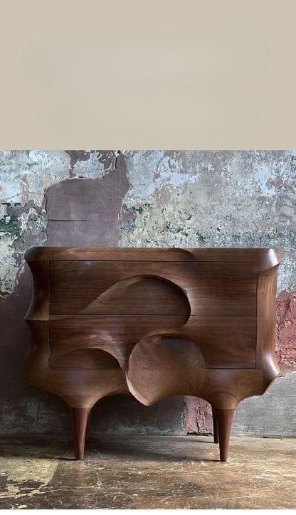 Wooden console table with abstract design against a textured wall.