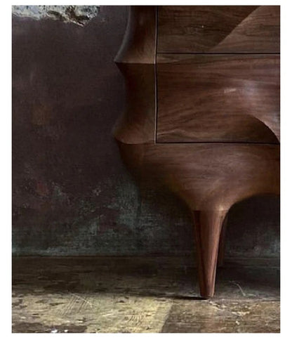 Wooden side table with a dark, textured wall and wooden floor in the background