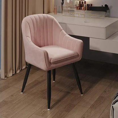 Pink velvet chair with black legs in a room setting