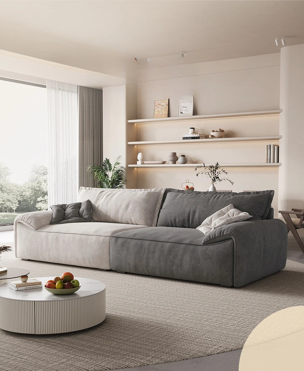 Modern living room with a gray sectional sofa, round coffee table, and shelves.