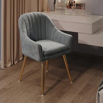 Gray velvet chair with gold legs in a room setting