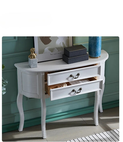 White console table with decorative items against a teal wall