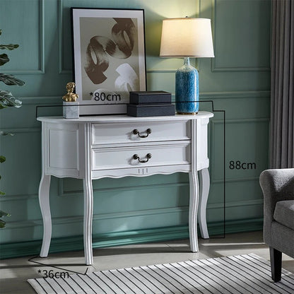 White console table with decorative items against a green wall