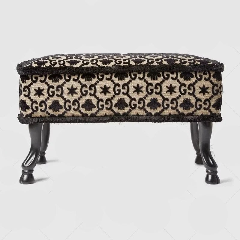 Patterned ottoman with black legs on a light gray background
