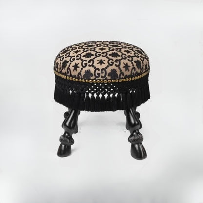 Decorative stool with leopard print top and black fringe on a white background
