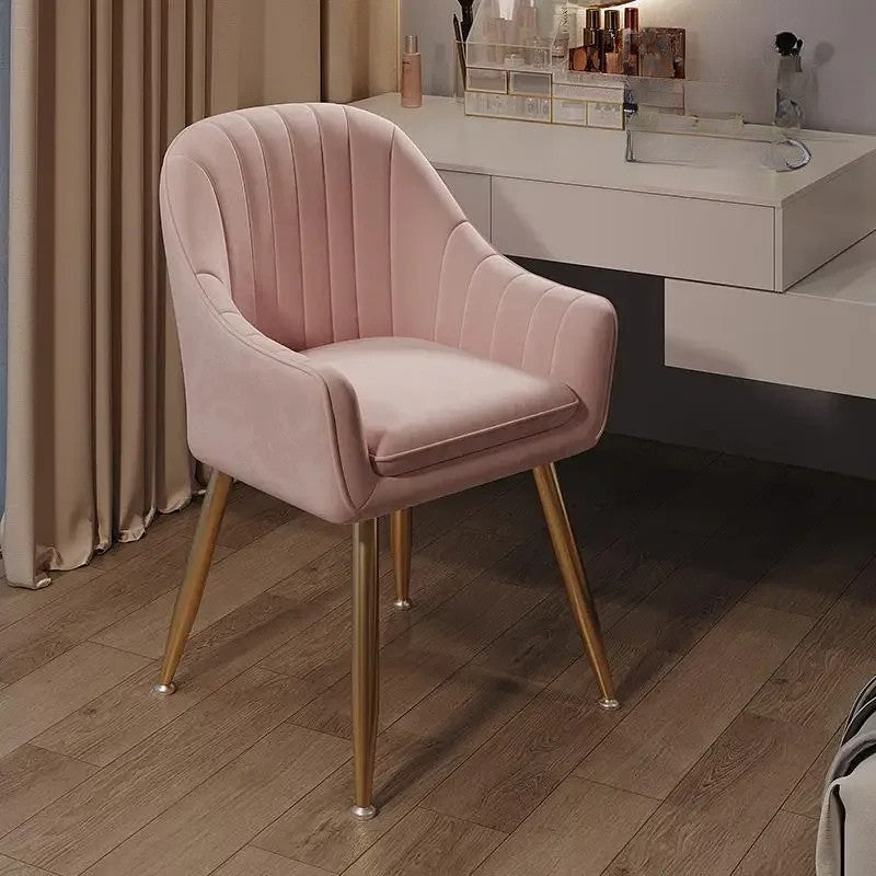 Pink velvet chair with gold legs in a room setting