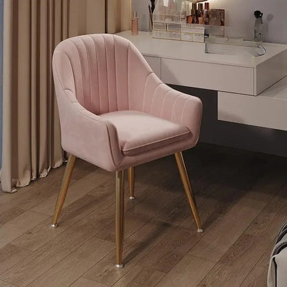 Pink velvet chair with gold legs in a room setting