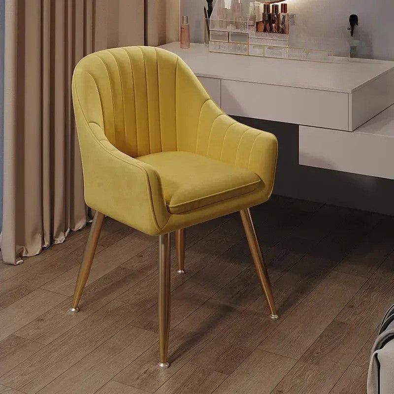 Yellow armchair with gold legs on a wooden floor