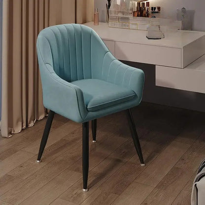 Teal velvet chair with black legs in a room setting