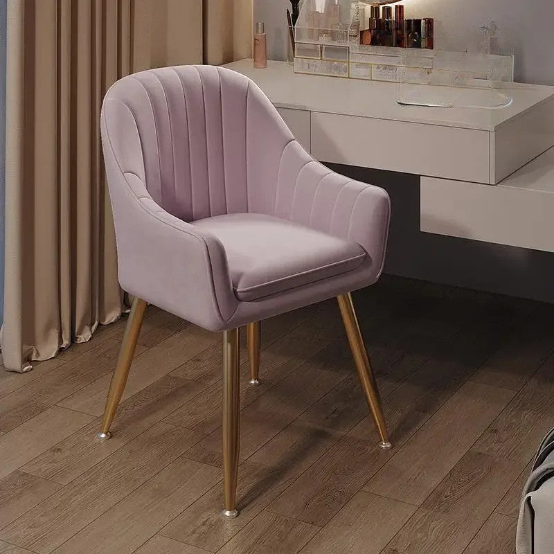 Pink velvet chair with gold legs in a room setting